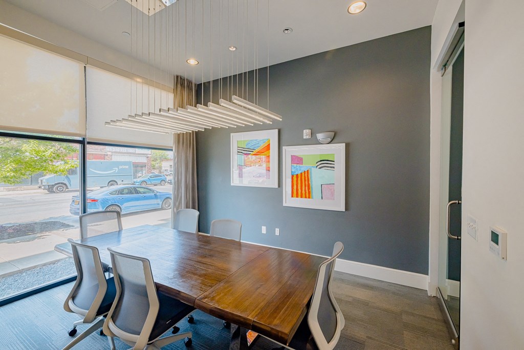a dining room with a wooden table and chairs and a large window