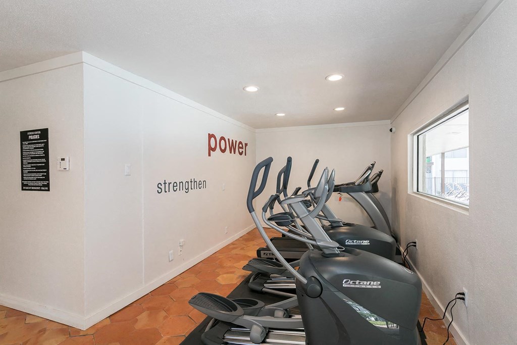 a room with a row of exercise machines and a sign on the wall that says power