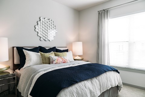 A bedroom with a large bed and a mirror on the wall.