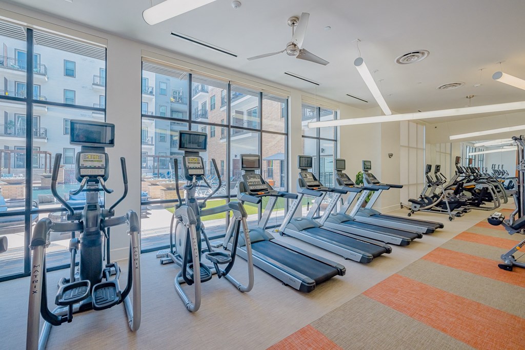 a cardio gym with cardio equipment and windows at the belgard apartments