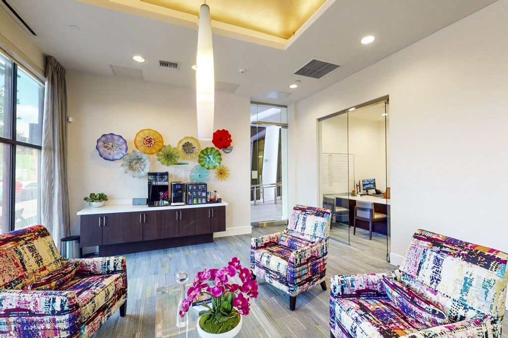 a living room with couches and chairs and a counter with colorful flowers