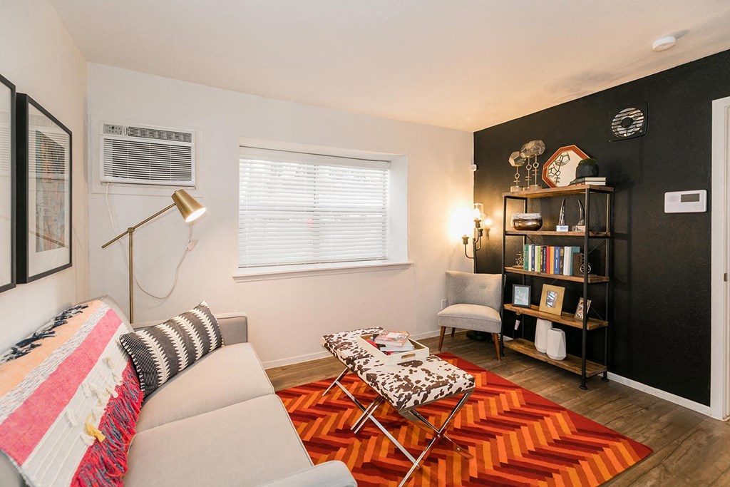 a living room with a white couch and orange rug