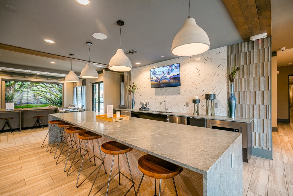 a large kitchen with a long counter top and chairs