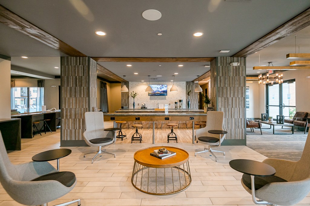 the lobby of a hotel with a bar and chairs