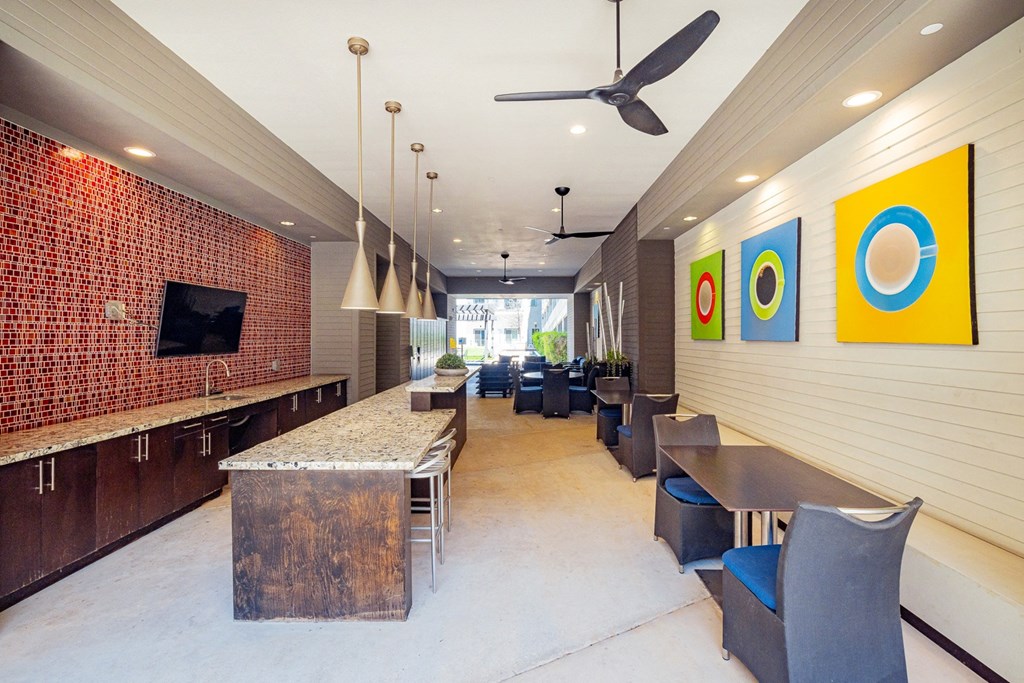 A long hallway with a row of chairs and a table.