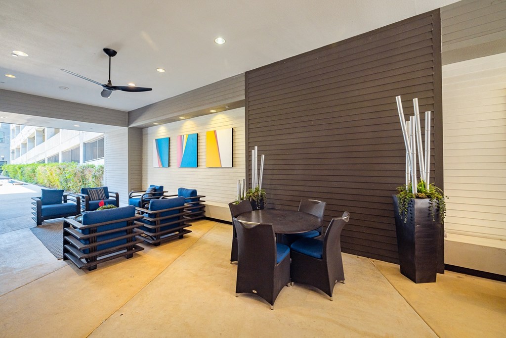 A room with a ceiling fan and a blue couch.
