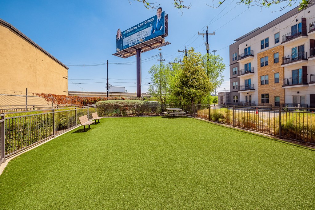 A grassy area with a bench and a billboard in the background.