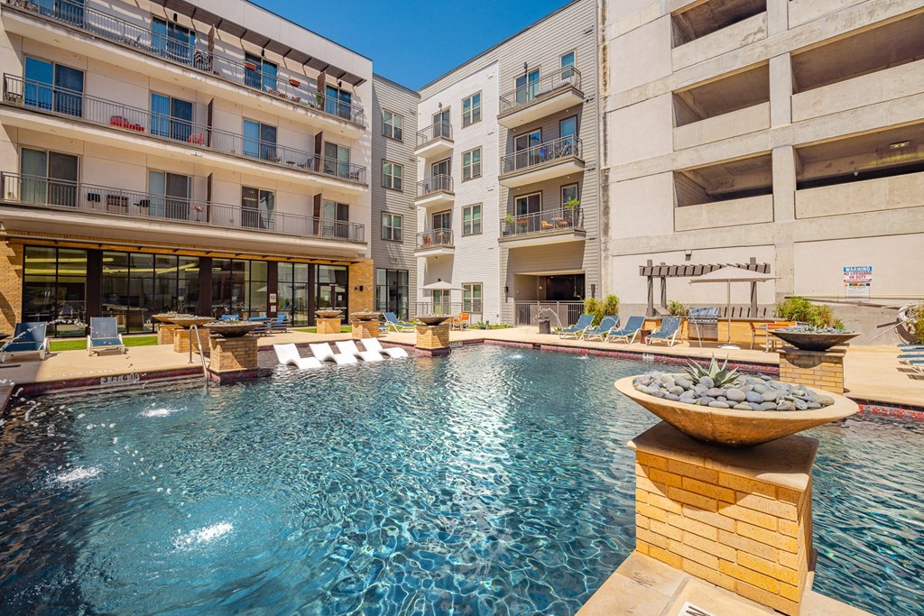 A large swimming pool in front of apartment buildings.