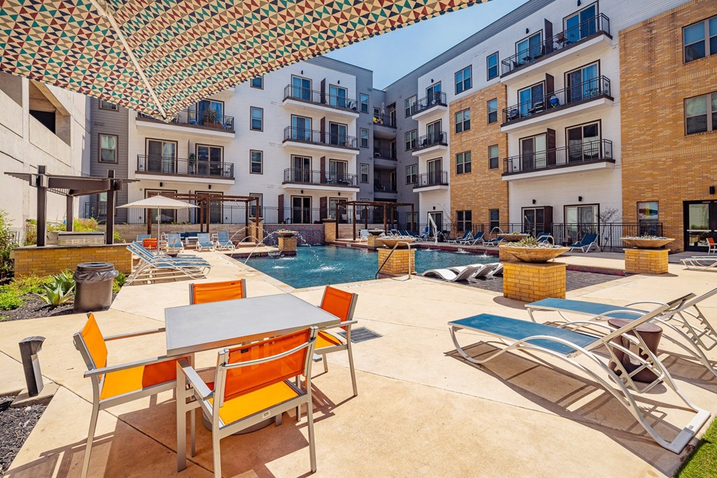 A patio with a table and chairs is surrounded by buildings.