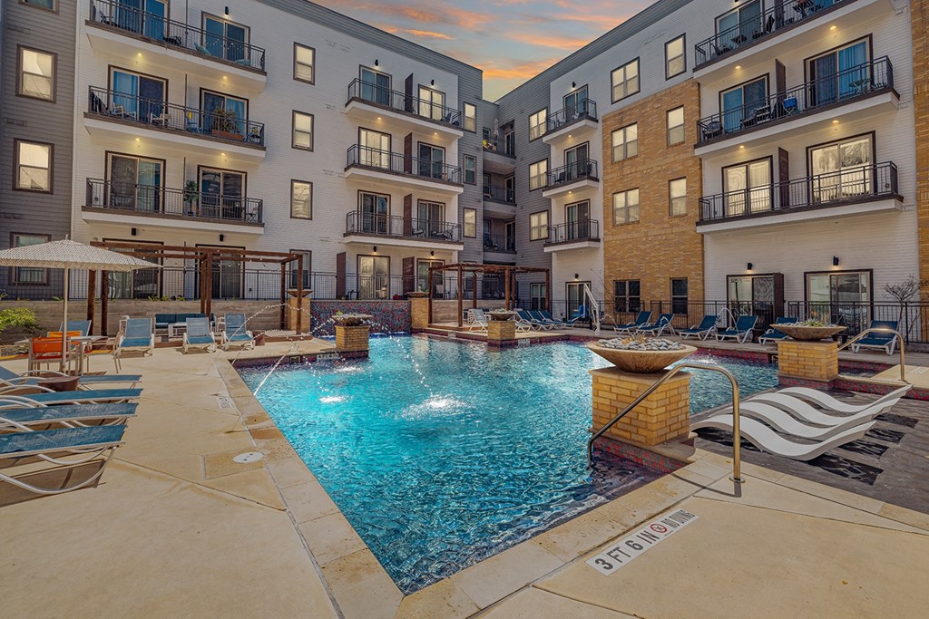 A swimming pool surrounded by apartment buildings.