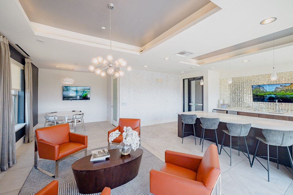 A modern living room with orange chairs and a wooden coffee table.