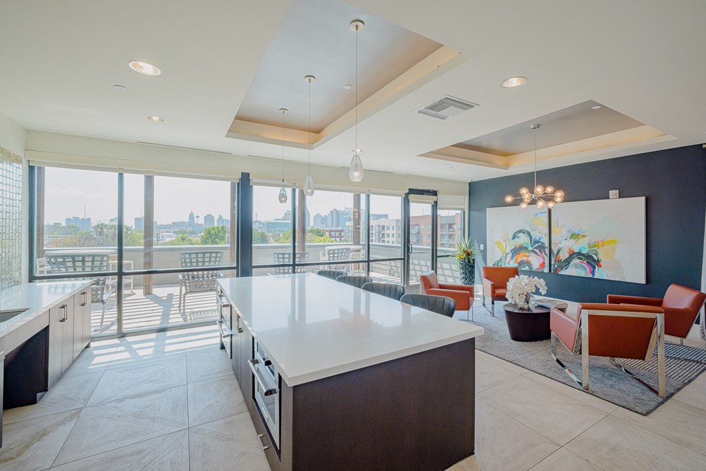 A modern kitchen with a large island and a view of the city.