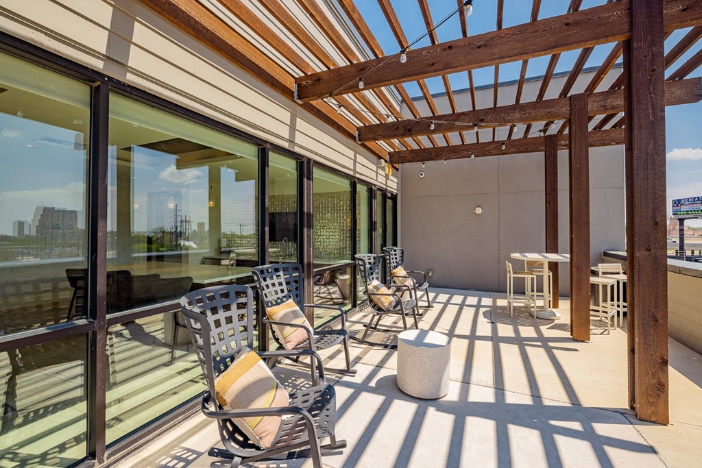 A sunroom with a wooden pergola and patio furniture.