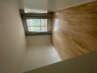 an empty room with a window and a wooden wall