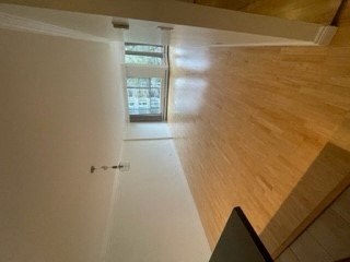 an empty room with a wood floor and a door