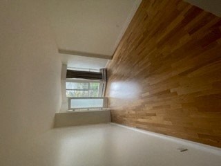 a room with a wooden wall and a window