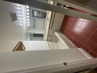 a small kitchen with a sink and a bath tub