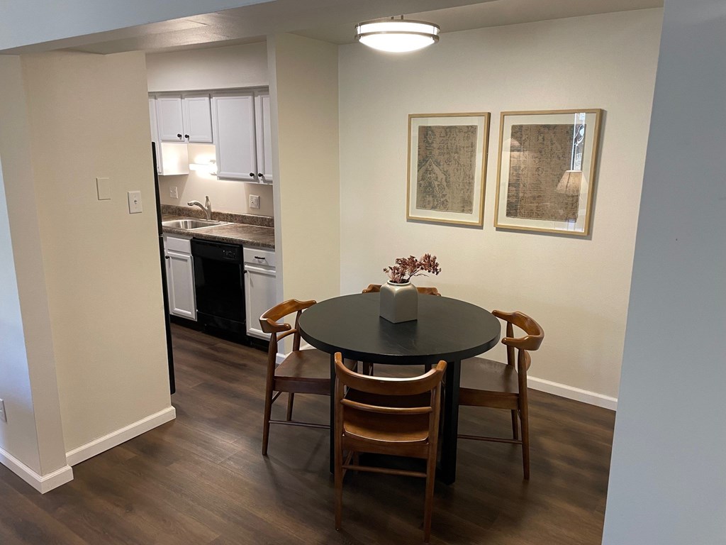 A kitchen with a dining table and chairs.