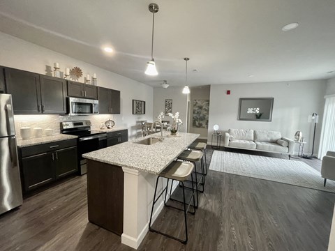 a kitchen and living room with a marble counter top