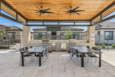 A patio with a table and chairs under a roof.