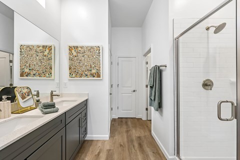 A bathroom with a white sink and a white shower.