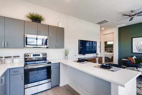 a kitchen with an island and a stove and a tv