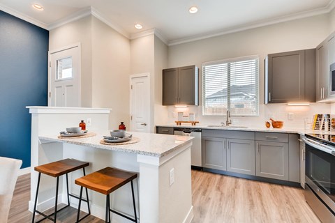 a kitchen with an island and stools in front of a counter