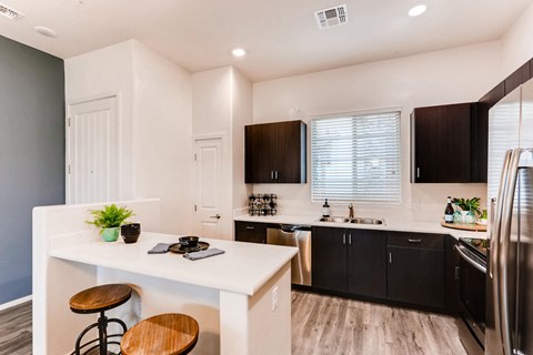 a kitchen with a white counter and black cabinets