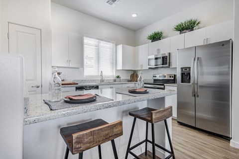 an open kitchen with stainless steel appliances and granite counter tops