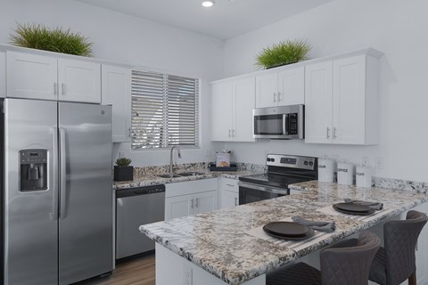 a kitchen with granite counter tops and stainless steel appliances