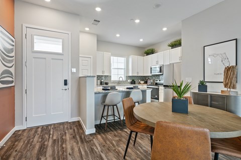 A modern kitchen with a dining table and chairs.