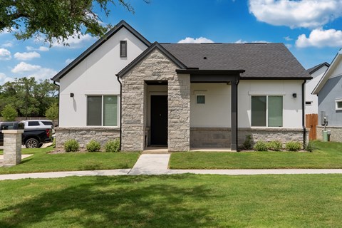 A house with a grey roof and a stone wall.