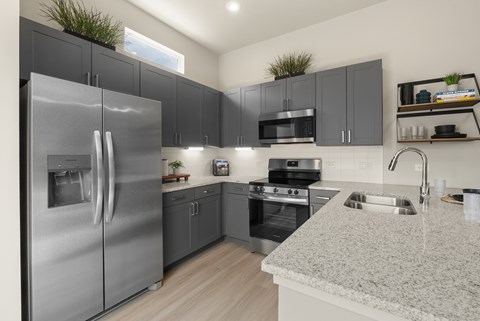 A modern kitchen with a stainless steel refrigerator and microwave.