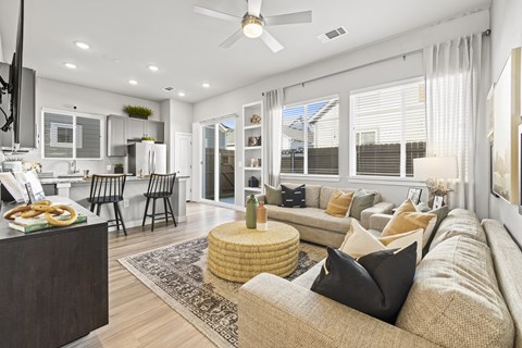 A modern living room with a beige sofa and a round wicker coffee table.
