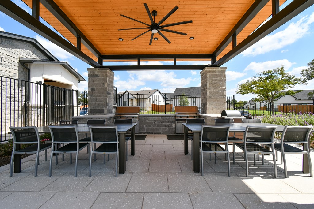 A patio with a table and chairs under a pergola.