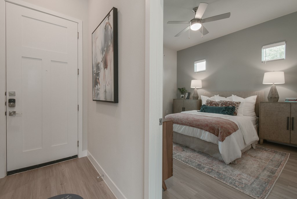 A bedroom with a bed, nightstands, and a painting on the wall.