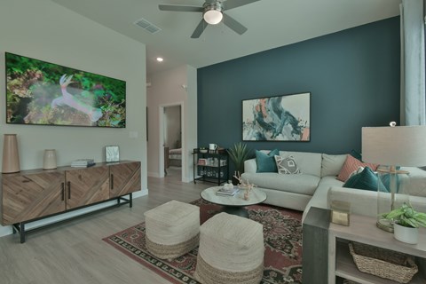 A living room with a rug, a couch, a table, and a painting on the wall.