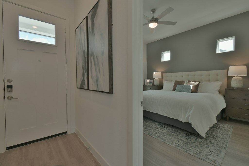 A bedroom with a bed, nightstands, and a ceiling fan.