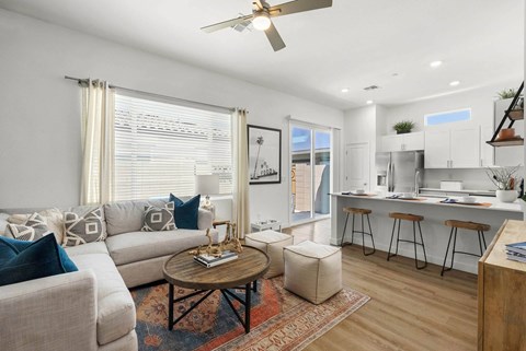 A living room with a couch, a coffee table, and a ceiling fan.