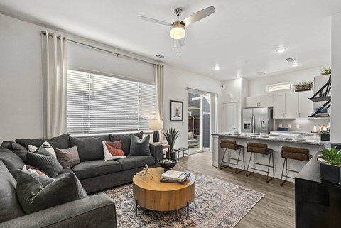 A modern living room with a grey sofa and a wooden coffee table.