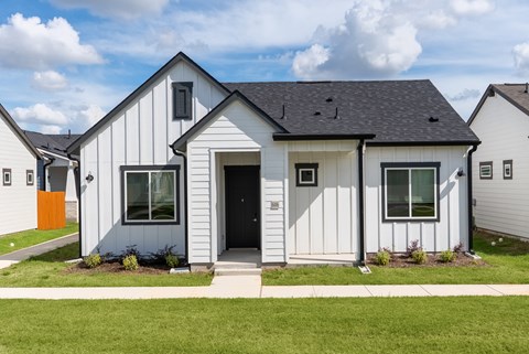 A white house with a grey roof and a black door.