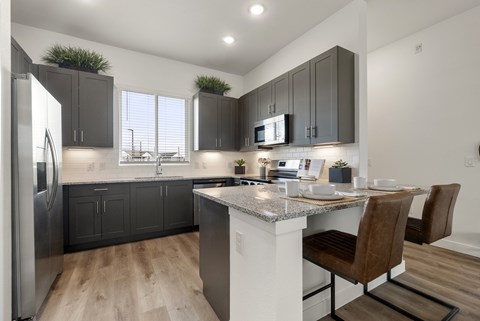 A modern kitchen with dark wood cabinets and a white island.