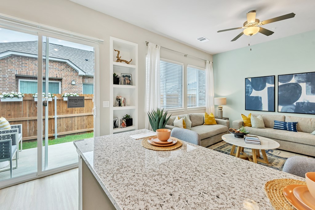 a living room with a kitchen and a sliding glass door at Avilla Towne Center Apartments, Texas, 75407