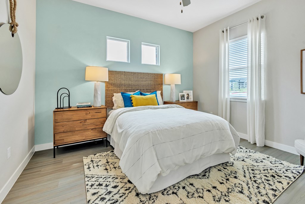 a bedroom with a bed and two windows at Avilla Towne Center Apartments, Texas, 75407