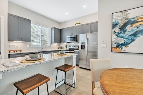 a kitchen with stainless steel appliances and a table and chairs