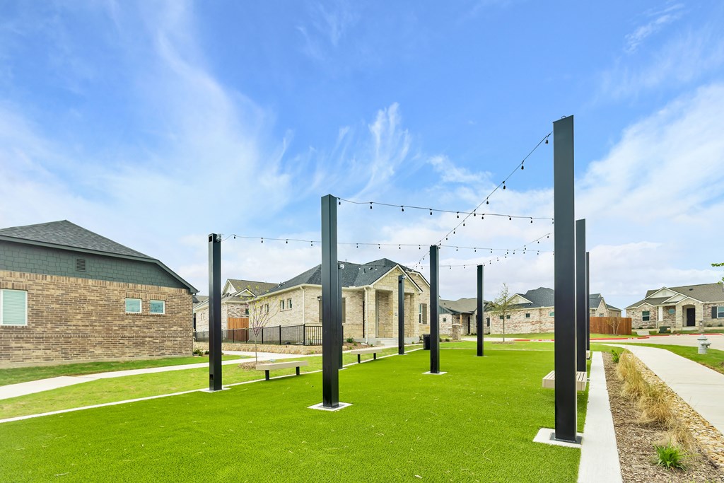 a group of poles in a yard with houses in the background at Avilla Towne Center Apartments, Texas, 75407