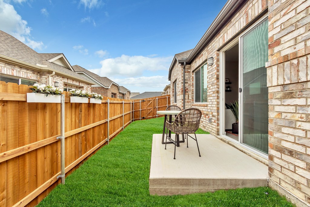 a backyard patio with a table and chairs and a fence at Avilla Towne Center Apartments, Texas, 75407