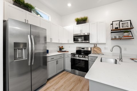 A modern kitchen with a stainless steel refrigerator and white countertops.