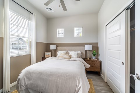 A bedroom with a large bed and a ceiling fan.