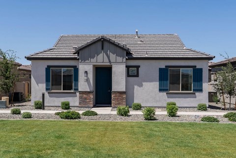 A house with a grey facade and a dark blue door.